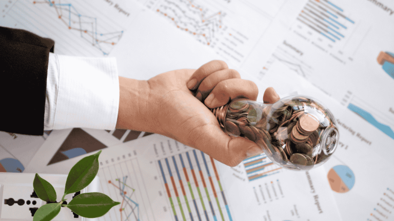 Auf dem Geschäftsdiagramm befindet sich eine Glühbirne mit Münze und Taschenrechner in der Hand eines Geschäftsmannes von oben.